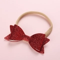 Close-up of red sequin bow on a soft nude nylon headband for infants and kids - Red