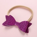 Detail of baby headband featuring a large purple sequin bow and soft nylon band - Fuschia