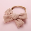 Détail du nœud en velours côtelé rose et du bandeau élastique en nylon pour bébé - Beige