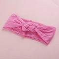 Détail d'un bandeau large en nylon rose doux avec un nœud torsadé pour les bébés - Rose d'Eau