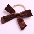Détail d'un nœud en velours marron foncé sur un bandeau élastique sans couture pour bébé - Marron