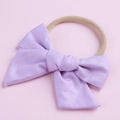 Détail d'un nœud en coton violet clair sur un bandeau en nylon élastique pour bébés - Violet