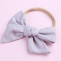 Détail d'un nœud en coton lilas doux sur bandeau en nylon élastique pour bébés - Gris