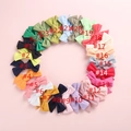 Lot de 24 barrettes nœuds en lin de couleurs unies pour bébés présentées en cercle - Couleurs mélangées au hasard