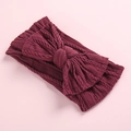 Detail of burgundy cable-knit headband for babies featuring a large soft textured bow - Burgundy