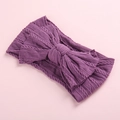 Deep purple knitted baby headband with large ribbed bow on a soft pink background - Light Purple