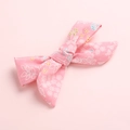 Detailed close-up of a pink floral fabric bow hair clip with delicate small flower patterns - Pink Floral