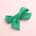 Détail d'une pince à cheveux avec nœud en coton vert montrant la texture du tissu - Vert 3