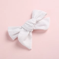 Détail d'une barrette à nœud blanc en tissu côtelé avec texture fine et design classique à deux couches - Blanc