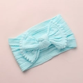 Détail du bandeau bébé bleu clair avec texture tricotée douce et grand nœud à pompons - Bleu Ciel