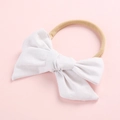 Gros plan d'un bandeau blanc à nœud en coton doux avec sangle élastique pour bébés - Blanc