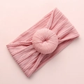 Close-up of pink knit baby headband with cable texture and 3D donut knot detail - Deep Pink