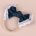 Detailed macro view of soft nylon baby headband with a teal lace edge bow decoration - Dark Blue