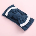 Detailed macro view of dark blue knit baby headband with white pom-pom trim bow - Dark Blue / White