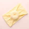 Detailed cable knit pattern on light yellow baby headband with donut knot design - Beige