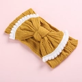 Detail of baby knitted headband featuring a bright yellow bow and fluffy white pom-pom trim - Ginger / White