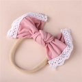 Detailed view of soft pink baby headband featuring lace edges and elastic nylon band - Dark Dusty Pink