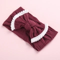 Detailed view of dark red knitted baby headband featuring white pom pom bow decoration - Wine Red/White