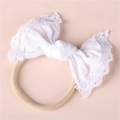 Detail of soft white lace bow baby headband with high-elastic nylon strap close-up - White