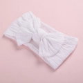 Detail of soft white cable knit texture and large bow on flexible baby headband - White