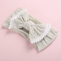 Détail d'un bandeau bébé en maille torsadée vert menthe avec nœud et pompons - Blanc Gris avec Bordure Blanche