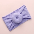 Detailed knit texture of light purple baby headband with donut knot on pink backdrop - Purple