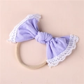 Detail of baby headband with light purple knitted bow and white lace trim on elastic nylon - Purple