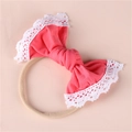 Detailed close-up of a pink soft fabric bow with white lace trim for infant headbands - Watermelon red