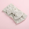 Detail of soft cream knitted baby headband with a large bow and cable knit texture - Off-White