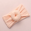 Detailed macro view of light pink knitted baby headband with a donut knot design - Dark Pink