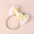 Close-up of baby nylon headband featuring a yellow bow with delicate white lace trim - Beige
