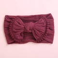 Détail du bandeau bébé en tricot torsadé bordeaux avec nœud et petits pompons - Rouge Vin avec Bordure Assortie