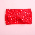 Detailed close-up of bright red infant headband with white polka dots and large soft bow - Red