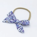 Detail of floral cotton bow baby headband with purple and blue blossoms on a nude nylon strap - Dark Floral (Style 5)