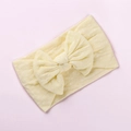 Dettaglio della fascia per neonati in nylon giallo chiaro con grande fiocco a pois bianchi - Beige
