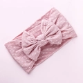 Dettaglio della fascia per neonati in nylon rosa a pois bianchi con grande fiocco decorativo - Rosa pelle