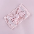Close-up of pink baby headband showing delicate white lace edges on a large bow - Light Pink