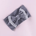 Detailed view of gray knit baby headband featuring an oversized bow with white lace trim - Gray