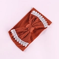 Detailed view of dark caramel nylon baby headband with white lace embroidered bow - Orange