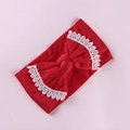 Detailed view of red baby headband with a large bow and white lace embroidery trim - Red
