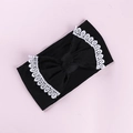 Detailed close-up of baby nylon headband with large black bow and white lace trim edge - Black