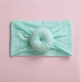 Detail of mint green baby headband with white polka dots and circular pleated knot - Light Green