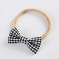 Détail d'un bandeau bébé en nylon élastique avec un nœud papillon à carreaux vichy - Gingham Noir et Blanc (1)