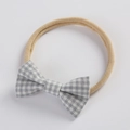 Close-up of baby headband with grey plaid bow and soft beige nylon elastic band - Gray and White Gingham (11)