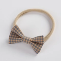 Detail of soft nylon baby headband featuring a classic blue and orange plaid bow - Blue and Orange Gingham (12)