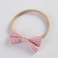 Detailed close-up of baby headband with a pink and white gingham bow on a soft elastic band - Pink and White Gingham (14)