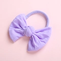 Detail of soft lavender nylon baby headband featuring a large elastic bow design - Purple