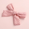 Close-up detail of a pink polka dot cotton bow hair clip for young girls and babies - Hair Bow / Pink Polka Dots