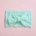 Detailopname van mintgroene babyhoofdband met zachte polkadot jacquard textuur en strik - Smaragdgroen