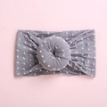 Detalle de una diadema gris para bebé con lunares blancos y un nudo redondo al centro - Gris